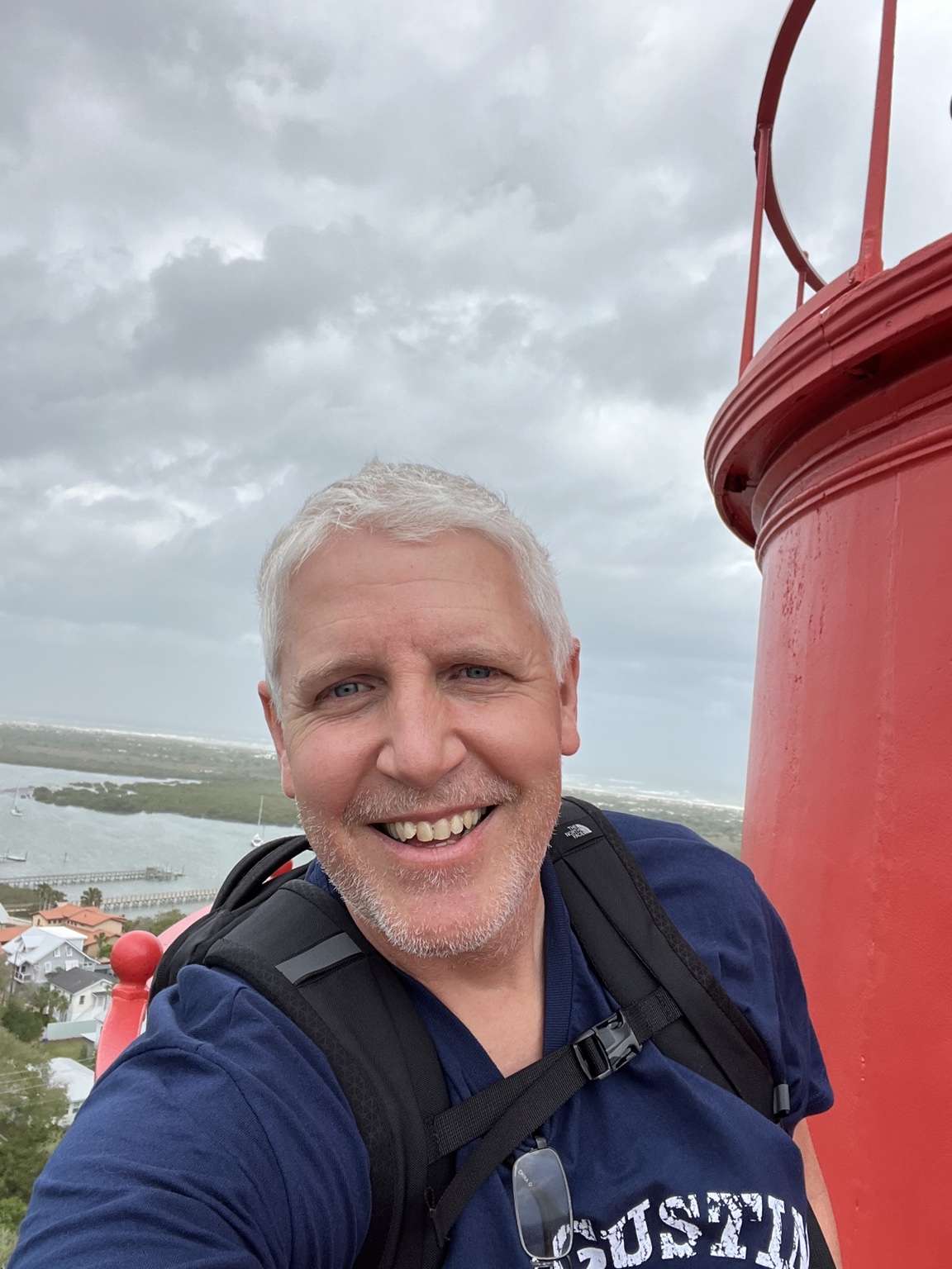 William McGlasson beside a red lighthouse.
